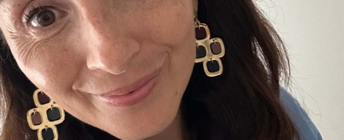 Wearing Hélène Elisabeth gold statement earrings with a blue shirt, the French wardrobe approach to everyday style