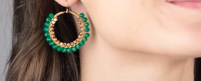 Model wearing gold-plated green hoop statement earrings, Hélène Elisabeth Jewellery